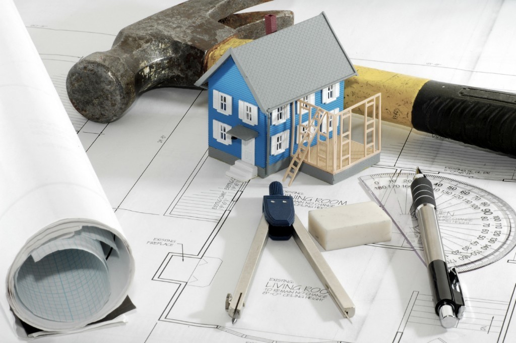 Home Renovation Miniature House With Various Drafting Items and Plans.