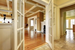 Hallway with an open door to a living room with an antique stove and chest.